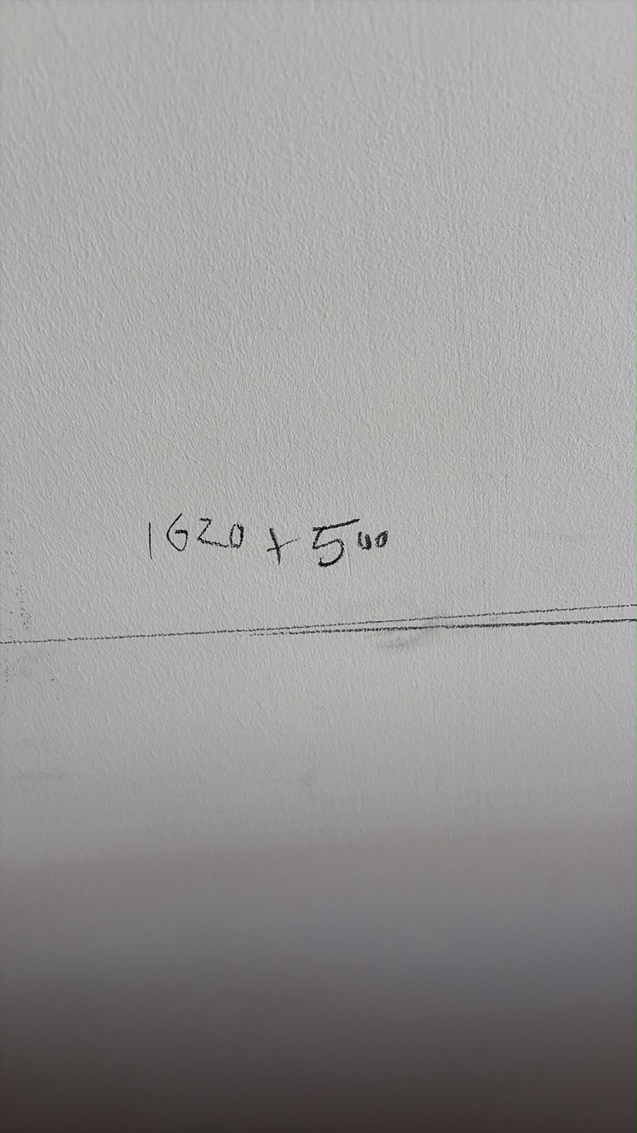 White textured wall with handwritten measurements '1620 + 500' and a pencil line marked on it.