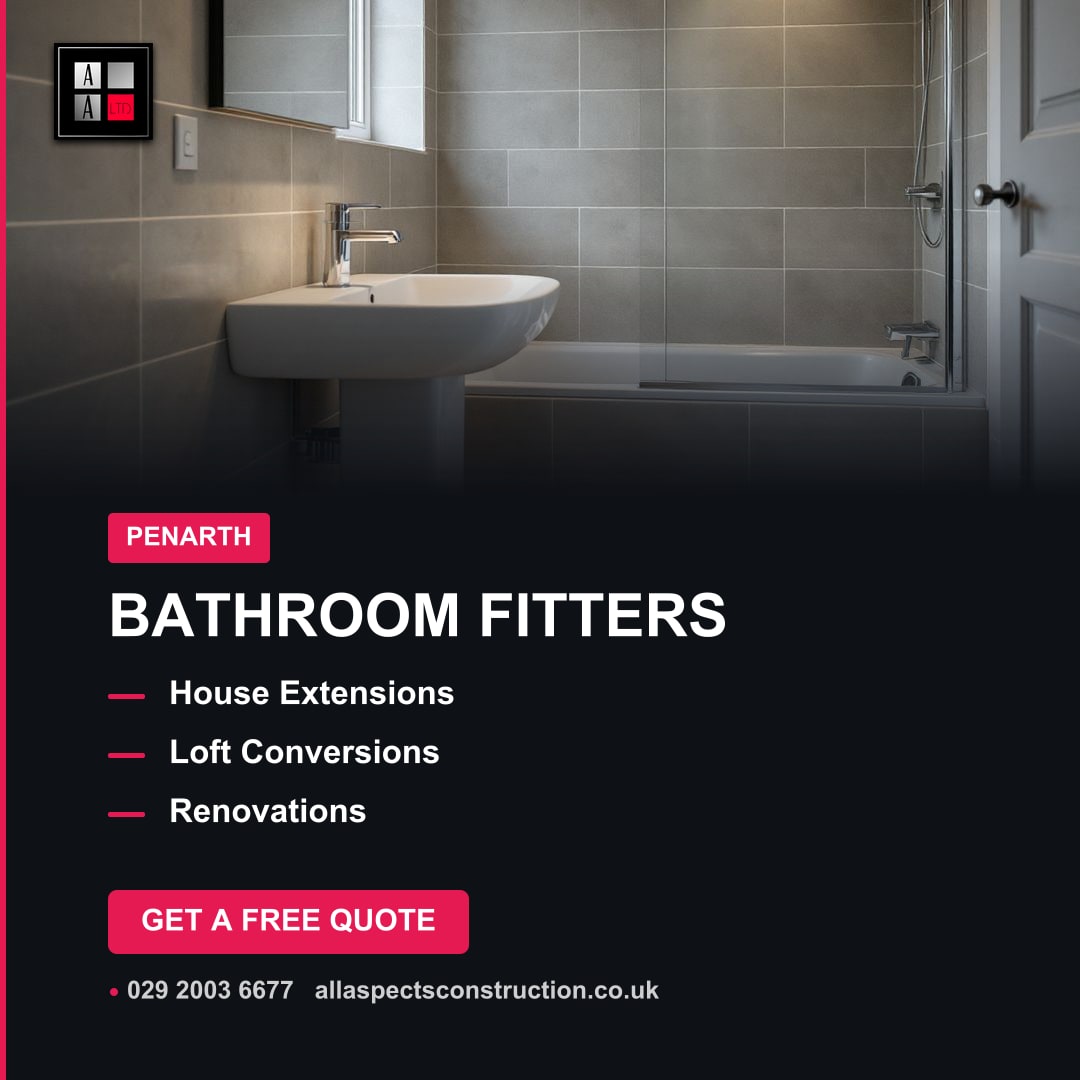 A modern, grey-tiled bathroom with a white wall-mounted basin, a mirror, and a bathtub with a clear glass shower screen.
