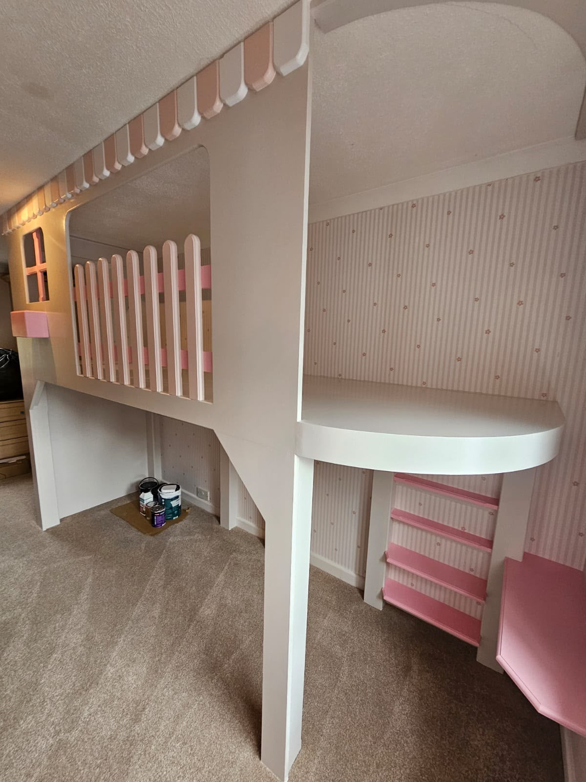 Custom-built loft bed with a play area underneath in a children's room.